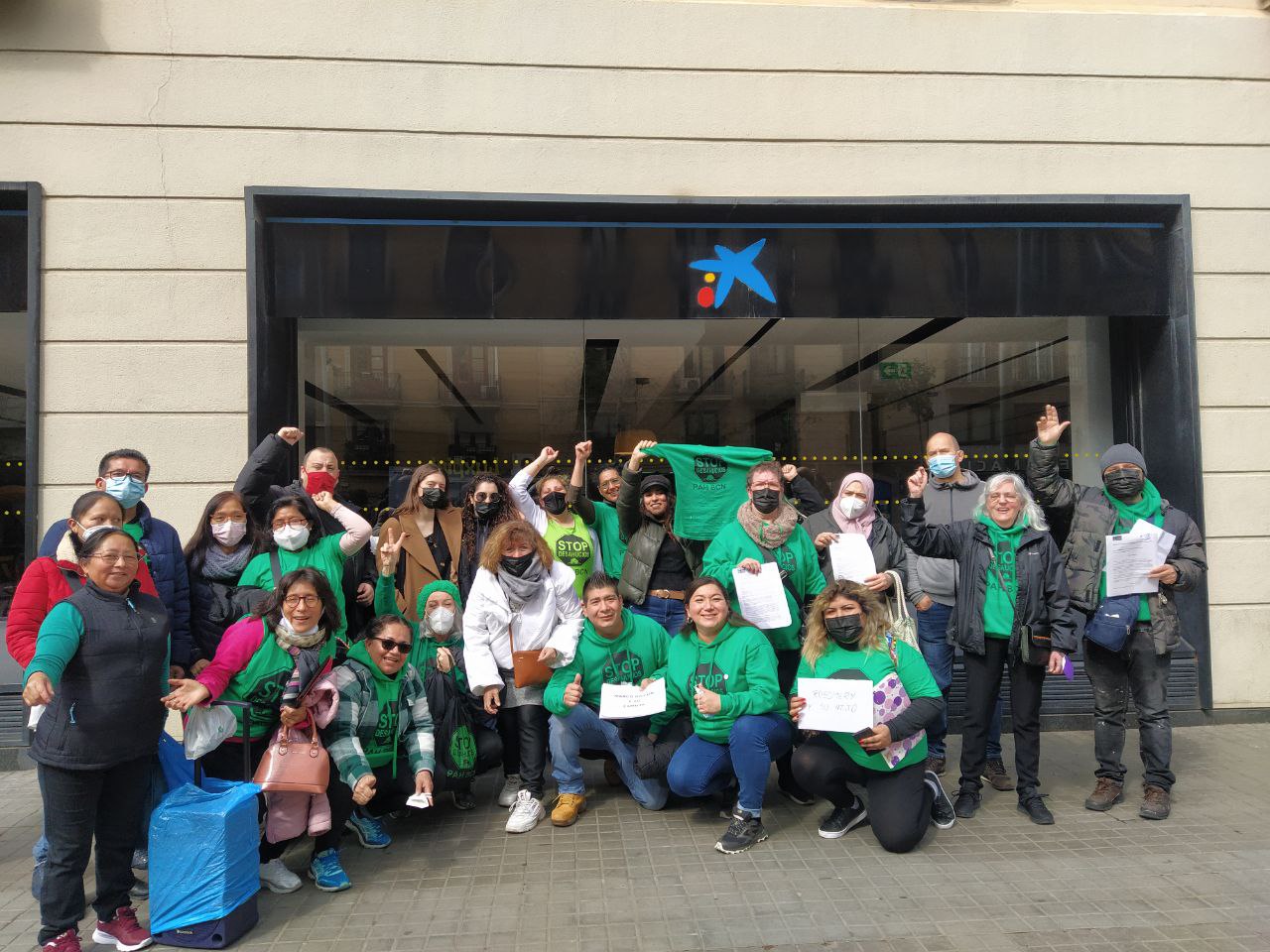 Grupo de activistas de PAH Barcelona delante de la oficina de Caixabank de Ronda Sant Antoni